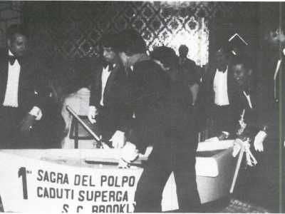 La sagra del polpo che viene allestita a Mola ha un suo corrispettivo anche nella Grande Mela. Fu predisposta per la prima volta a Brooklyn nel 1979 dai �Caduti di Superga Mola Circolo Culturale Inc.� e da allora ha continuato ad avere successo (Foto tratta dal catalogo della mostra fotografica "Cento anni di Emigrazione all'Estero da un'Area del Sud-Est Barese")